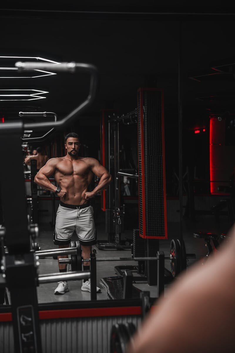 Athletic man performing strength training in a gym with modern equipment.