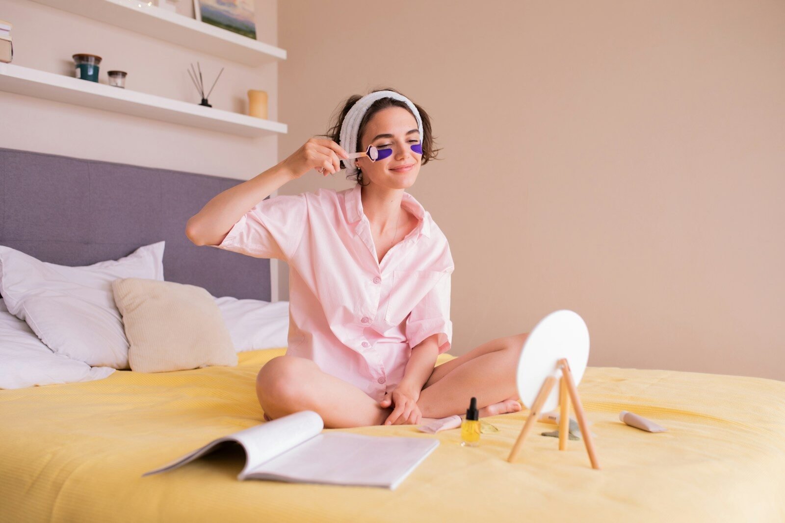 a woman sitting on a bed wearing a pink robe